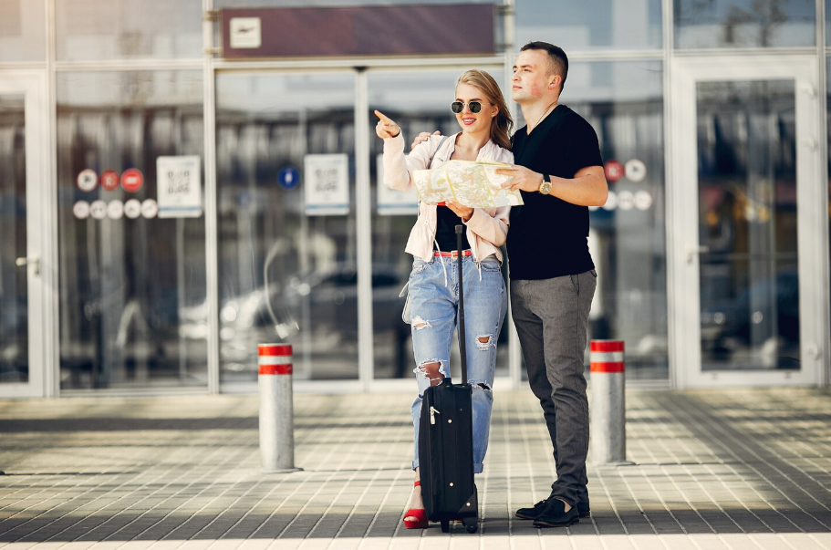 Couple checking directions at cruise port terminal before embarkation, avoiding first-time cruise mistakes