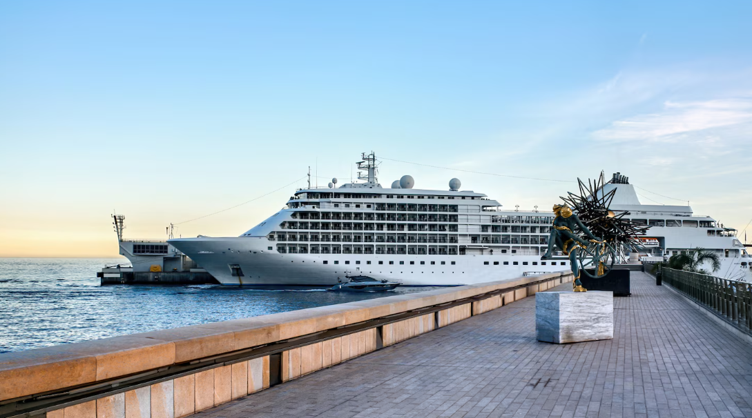 Luxury cruise ship docked at port at sunrise