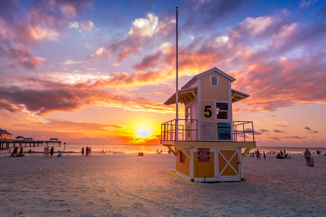 Clearwater Beach lifeguard tower at sunset with vibrant skies and visitors on the sand