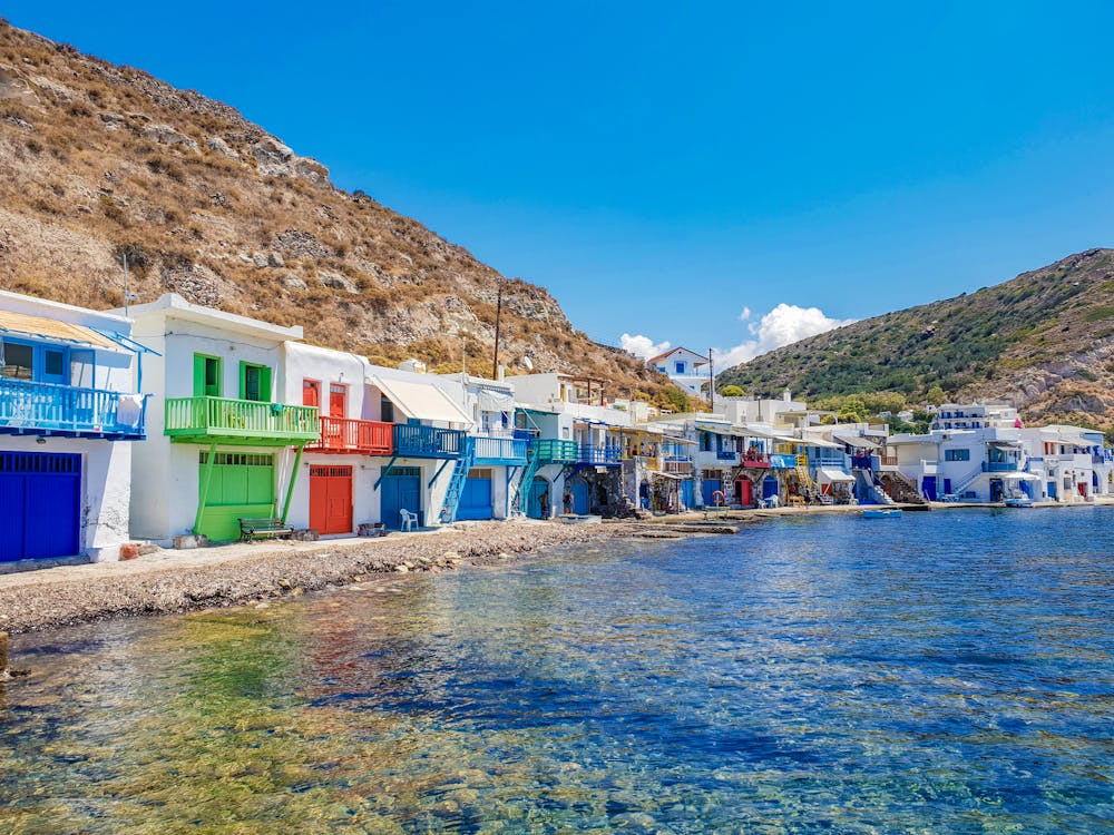 Colorful fishermen’s houses along the waterfront in Milos, Greece, a less crowded Greek islands travel option
