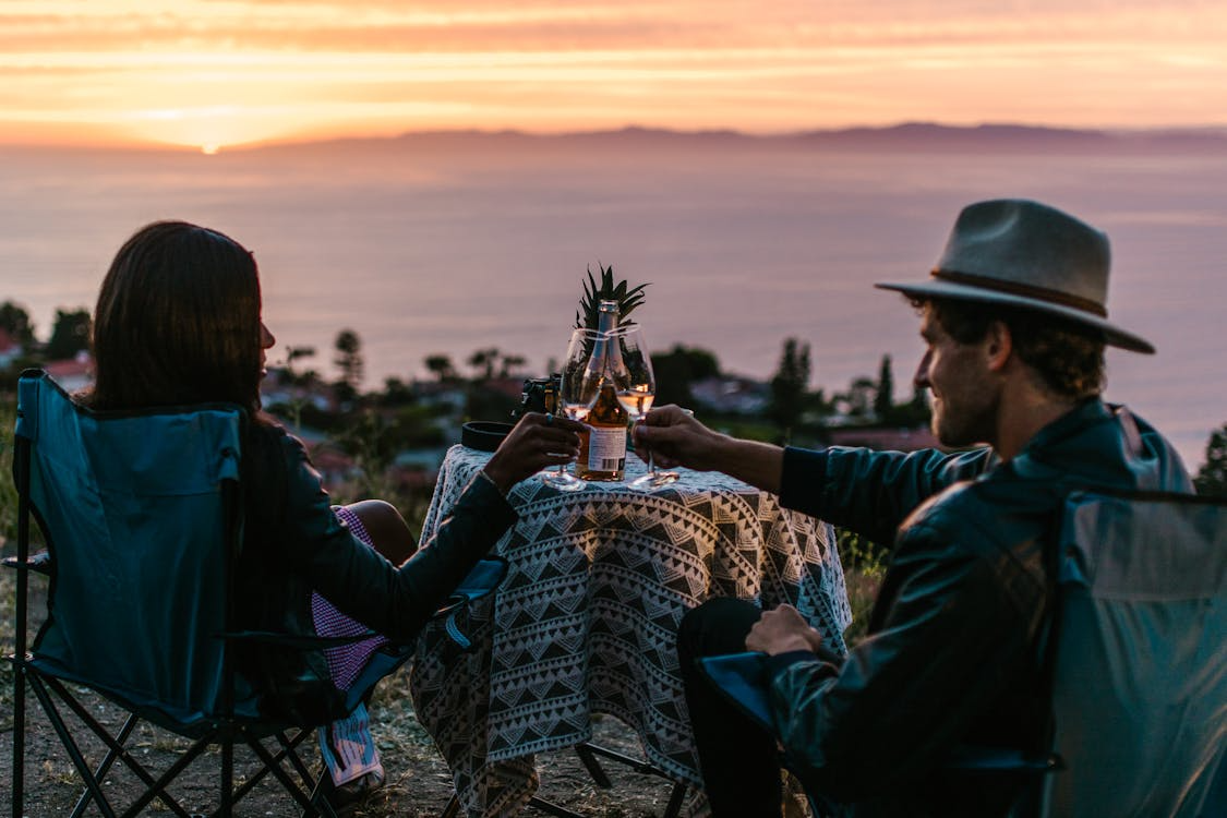 Couple enjoying sunset drinks overlooking the ocean at one of the best luxury beach clubs