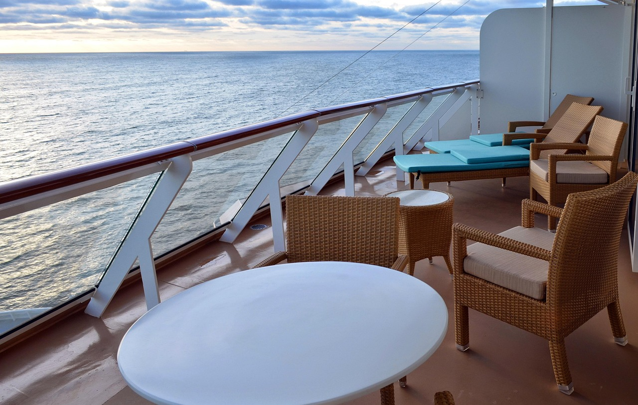 Private cruise ship balcony suite with ocean view and lounge chairs