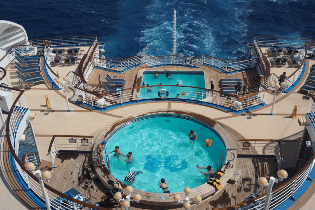 Aerial view of a family-friendly cruise ship deck with swimming pools and ocean views