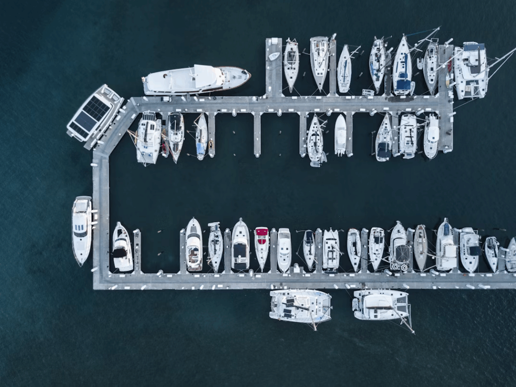 Aerial view of luxury yachts and sailboats docked at a marina before Yacht Week departure