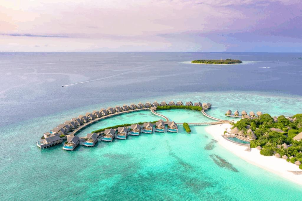 Aerial view of luxury overwater villas in the Maldives surrounded by turquoise lagoon waters and white sandy beaches