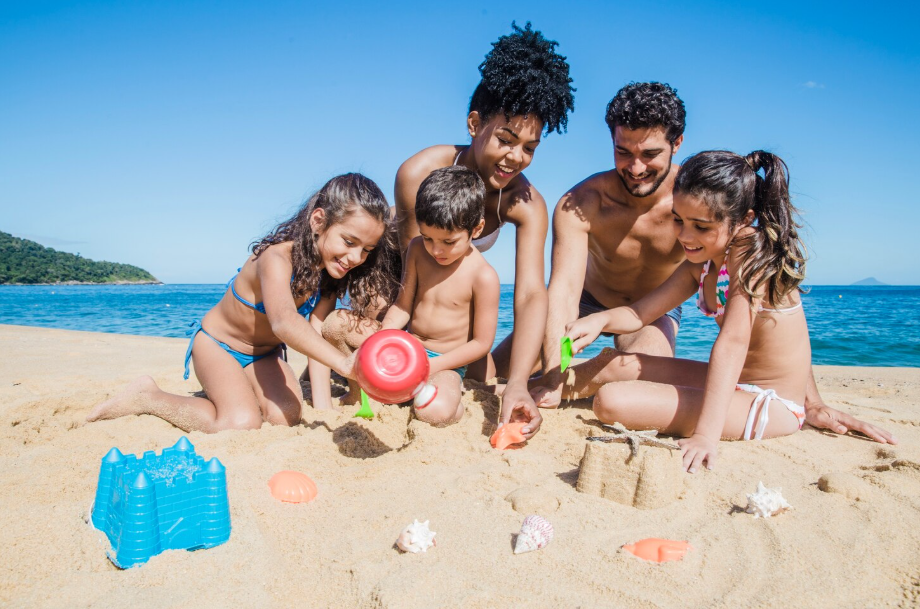 happy family building sandcastles together at a family beache in the U.S.
